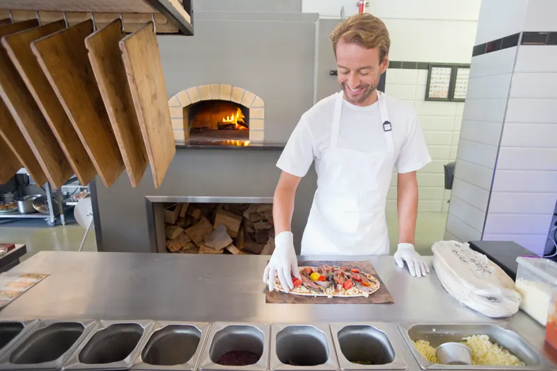 Pizzabagare gör pizza i restaurangkök