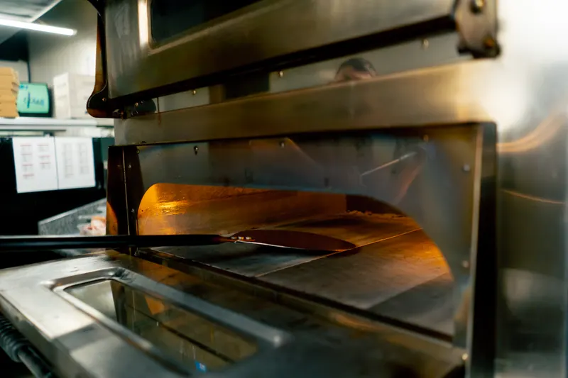 Professionell pizzaugn i arbete i restaurangkök