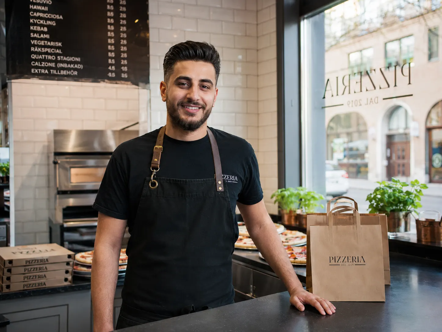 Restoranındaki tezgahın başında pizzacı sahibi