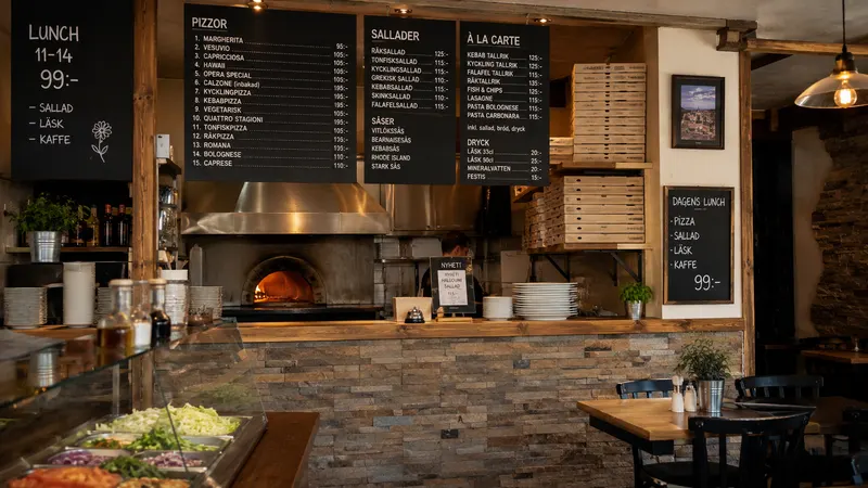 Rustik pizzerialokal med vedugn och menytavlor