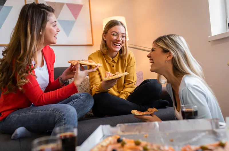 Glada vänner delar pizza tillsammans
